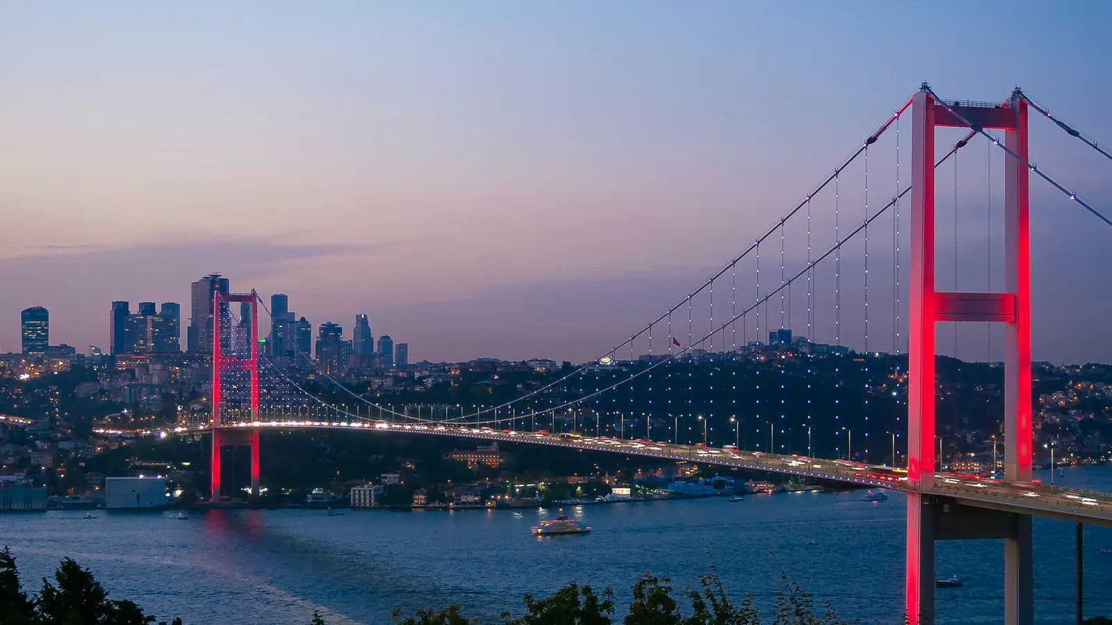 Akşam ışığında İstanbul Boğazı üzerindeki köprü ve şehir silueti